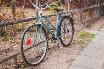 Fototapeta na wymiar Parked Vintage Old Bicycle Bike In Courtyard. Autumn