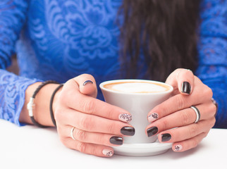 mug of coffee in their hands girl with a nice manicure
