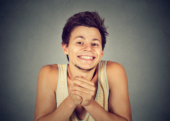 Kind young man showing clasped hands, pretty please