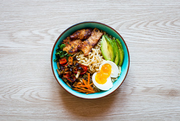 Japanese noodles bowl with chicken, carrots, avocado