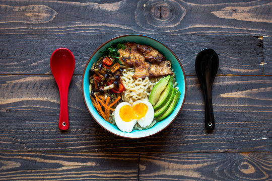 Japanese noodles bowl with chicken, carrots, avocado