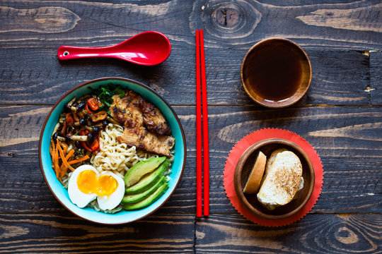 Japanese noodles bowl with chicken, carrots, avocado