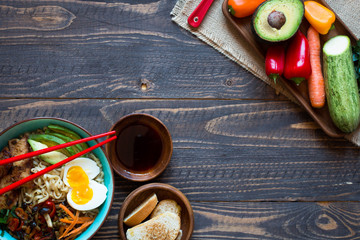 Japanese noodles bowl with chicken, carrots, avocado