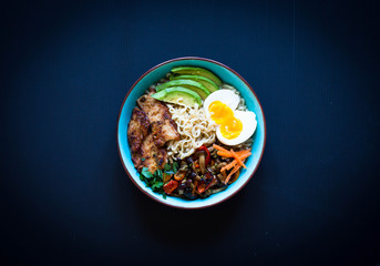 Japanese noodles bowl with chicken, carrots, avocado