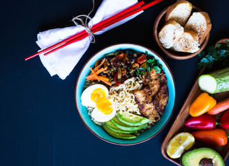 Japanese noodles bowl with chicken, carrots, avocado