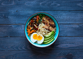 Japanese noodles bowl with chicken, carrots, avocado