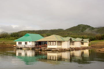 Fototapeta na wymiar houseboat in lake and green mountain background
