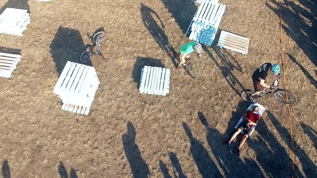 Cyclists jump over man in bicycle aerial video. MTB tricks in Mountain bike trial. Extreme sport lifestyle