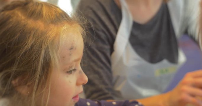 Kid Sitting at the Table Painting Rubber Stamps Letters on the Table Art Gallery People Paint in Kindergarten Classroom Educators Mums Families and Kids