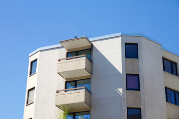 View on apartment building with balcony against a blue sky
