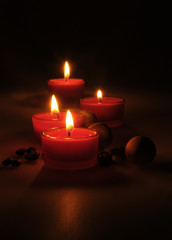 spa composition. scented candles, coffee beans, aromatic wooden balls and oil in a glass jug with a stopper. Photo executed in a dark key. partially tinted photo.