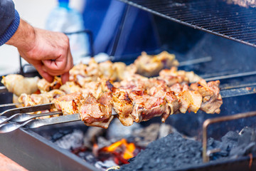 Shish kebab on skewers (beef, pork, chicken) are roasted over th