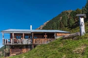 Obraz premium Obere Bacherwandalm im Stubaital mit Holzbrunnen