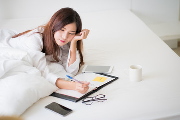 Asian woman working on the bed.