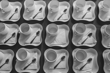 Many rows of white ceramic coffee or tea cups.