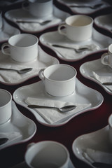 Many rows of white ceramic coffee or tea cups.