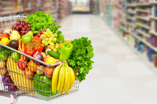 Grocery shopping cart with vegetables.