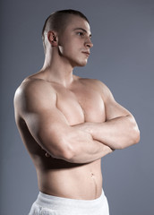Fototapeta premium strong brutal short-hair man bodybuilder with muscular isolated on gray background