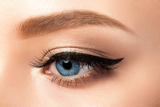 Fototapeta Close up view of blue woman eye with beautiful makeup