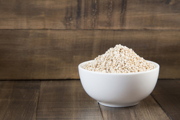 White quinoa seeds on a wooden background