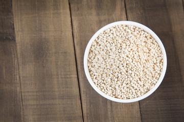 White quinoa seeds on a wooden background