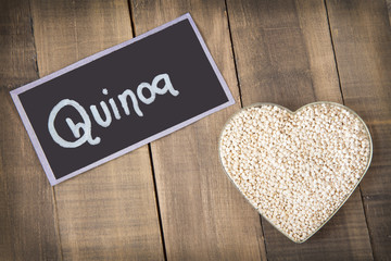 White quinoa seeds on a wooden background