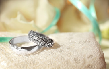Beautiful wedding rings on white fabric background