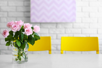 Bouquet of fresh roses on white table