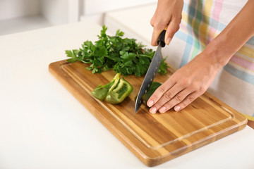 Woman slicing pepper on cutting board