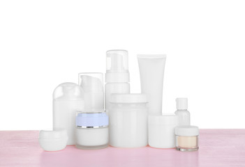 Different cosmetic bottles on table on white background