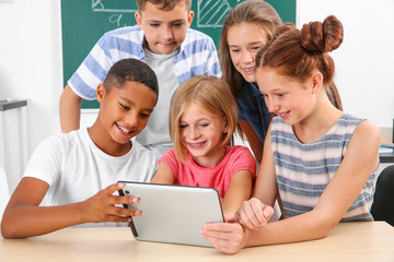 Schoolchildren with tablet computer in classroom
