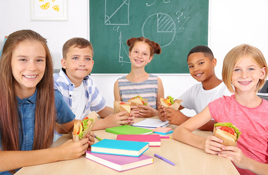 Schoolchildren having lunch in classroom