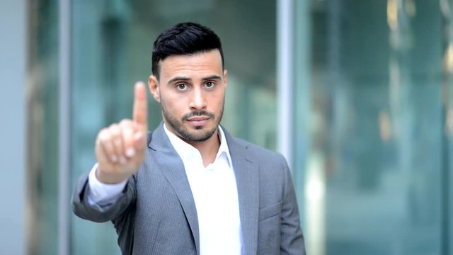 Young man saying no with his finger