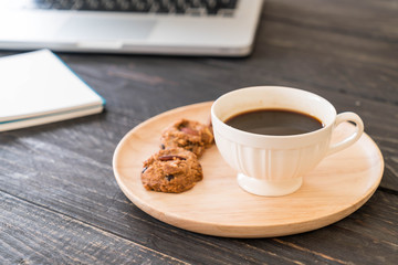 black coffee and cookies with laptop and note book