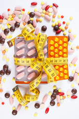 Obraz premium Blisters of medical pills and capsules wrapped centimeter, health care healthy lifestyle and slimming concept
