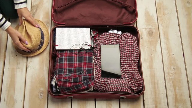 wonan packing a suitcase and close it