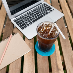 cup of coffee with Laptop (notebook) and notepad with pen on old