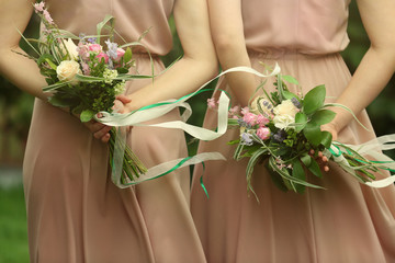 Beautiful bridesmaids holding bouquets