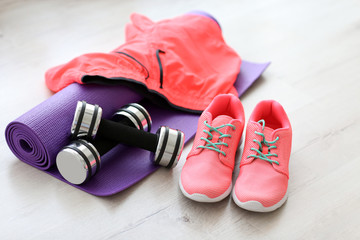 Comfortable sneakers with sport tools on floor