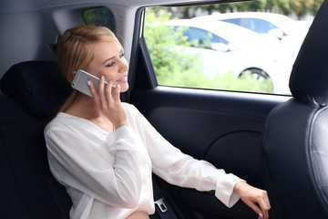 Businesswoman speaking by cellphone in  a car