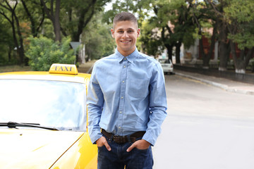Male taxi driver near car