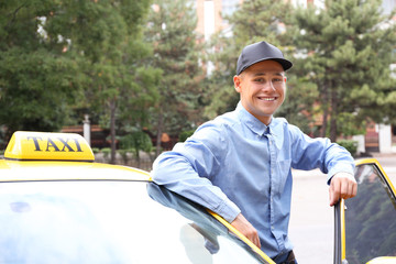 Male taxi driver near car