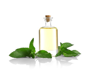 Essential aroma oil in glass bottle with fresh mint leaves on white background