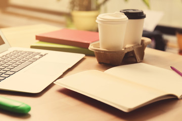 Workplace with notebook, laptop and cup of coffee, close up