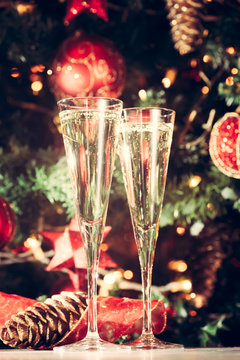 Two glasses of champagne with Christmas tree background. Holiday