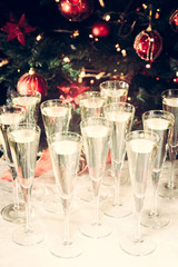 Glasses of champagne with Christmas tree background. Many glasse