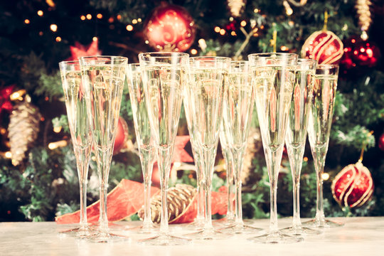 Glasses of champagne with Christmas tree background. Many glasse