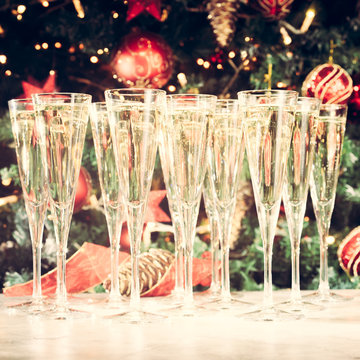 Glasses of champagne with Christmas tree background. Many glasse