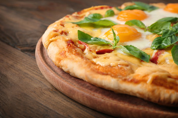 Margarita pizza with basil leaves and egg on wooden background