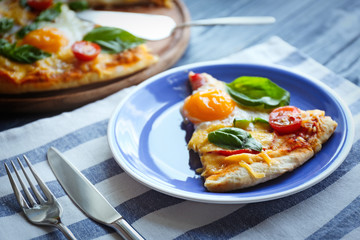 Piece of Margarita pizza with basil leaves and egg on plate closeup